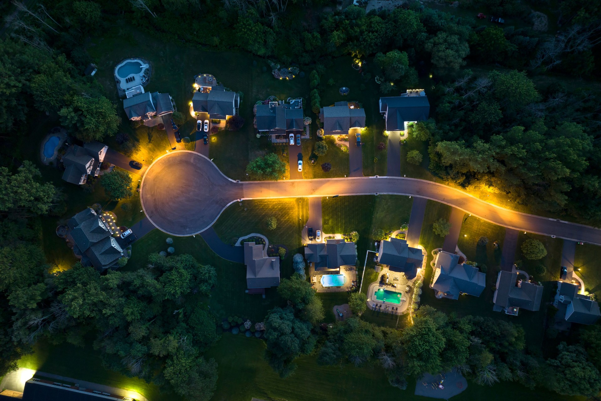 View from above of residential houses in living area in Rochester, NY at night. Illuminated american dream homes as example of real estate development in US suburbs